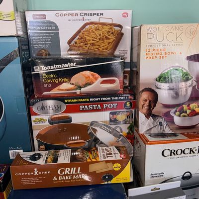 Collection of boxed kitchen appliances and cookware including a Gotham Steel pasta pot, Copper Crisper tray, Toastmaster Electric Carving...