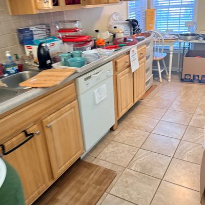 Kitchen area featuring light oak cabinets filled and covered with various cookware, dishware, small appliances, and household items for...