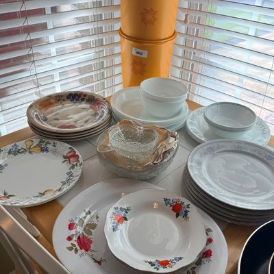 Assorted vintage kitchenware including a stack of Tupperware canisters in harvest gold, various ceramic and Corelle dinnerware sets, and...