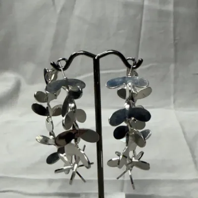 Silver-tone hoop earrings adorned with delicate, petal-like embellishments