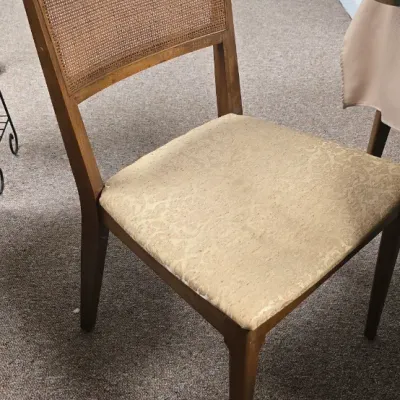 Sale Photo Thumbnail #41: Mid-century modern wooden dining chair featuring a woven cane backrest and a beige upholstered seat.