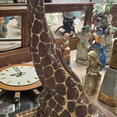 Sale Photo Thumbnail #39: Vintage ceramic giraffe featuring hand-painted spots and a glossy finish, displayed on a mirrored tray.