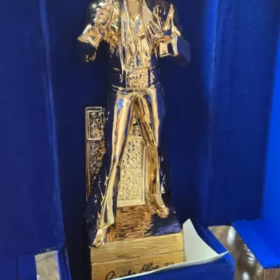 Sale Photo Thumbnail #33: Gold-tone Elvis Presley commemorative statue housed in its original blue velvet-lined display box.