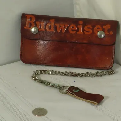 Vintage brown leather Budweiser trucker wallet featuring embossed orange lettering, double snap closures, and a metal chain with belt loop.