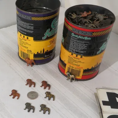 Two vintage Chock full o'Nuts coffee cans filled with metal bulldog figurines, accompanied by several loose figurines and a US...