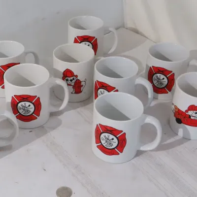 Set of nine white ceramic coffee mugs featuring firefighter insignias and Dalmatian illustrations.