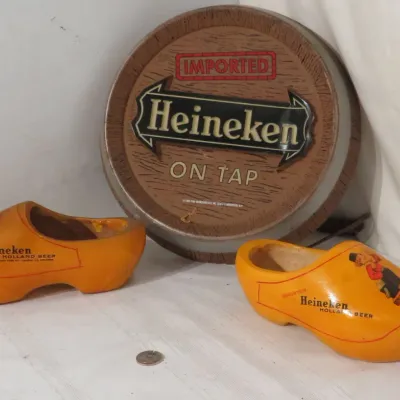Vintage Heineken breweriana collection featuring a round plastic barrel head "On Tap" light-up sign alongside a pair of branded...