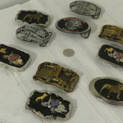 Collection of vintage Mack Trucks brass and metal belt buckles featuring semi-truck designs and bulldog logos.