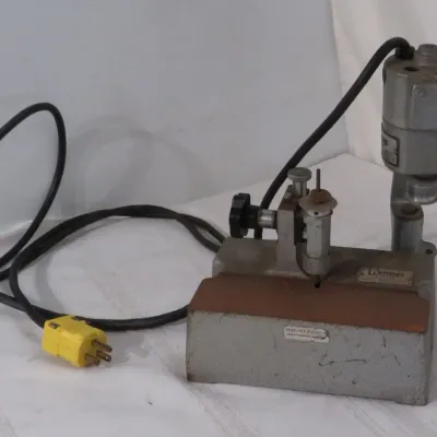Vintage Hermes motorized beveler tool with attached power cord and metal base. Shows moderate surface wear, scuffs, and patina consistent...