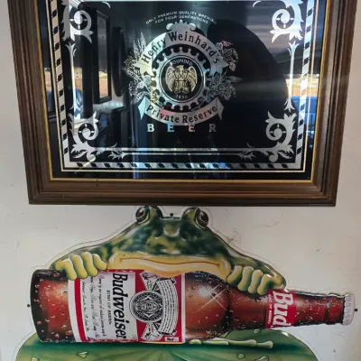 Sale Photo Thumbnail #107: Vintage framed Henry Weinhard's Private Reserve Beer bar mirror mounted above a 1990s Budweiser frog embossed plastic advertising sign.