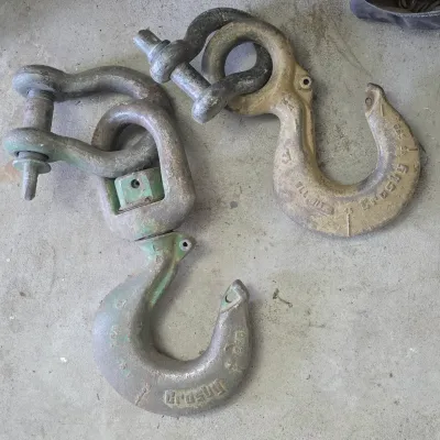 Sale Photo Thumbnail #45: Pair of vintage Crosby heavy-duty swivel crane hooks with attached shackles, displaying weathered metallic finishes.