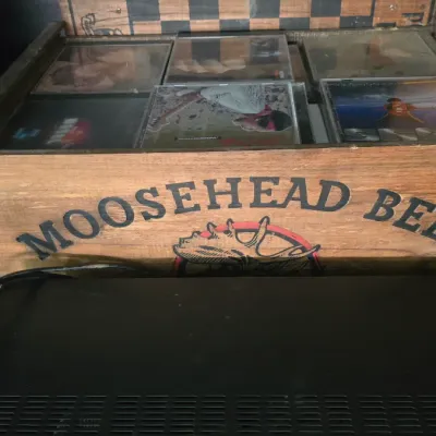 Sale Photo Thumbnail #20: Vintage Moosehead Beer wooden crate filled with music CDs in jewel cases.