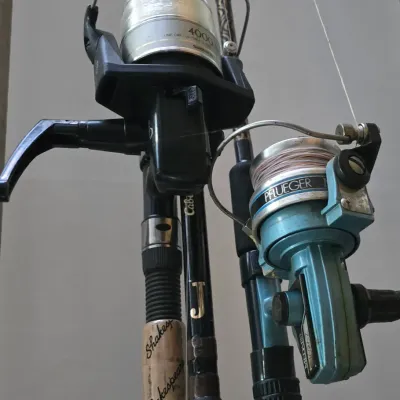 Sale Photo Thumbnail #50: Collection of fishing rods featuring spinning reels including a black Shimano 4000 and a blue Pflueger Medalist, mounted on Shakespeare and Cabela's rods in good used condition.