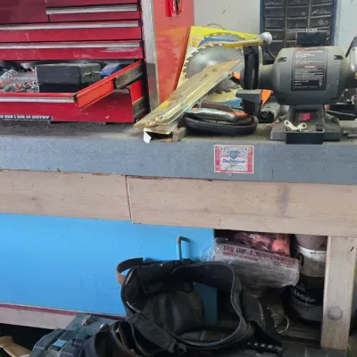 Sale Photo Thumbnail #77: Workshop setup featuring a red metal tool chest, bench grinder, two DeWalt toolboxes, and a Stanley tool belt.