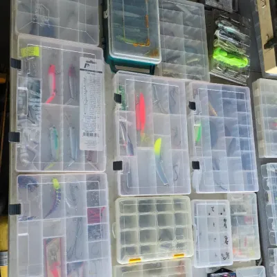 Sale Photo Thumbnail #64: Large collection of plastic tackle utility boxes filled with various fishing lures, hooks, and terminal tackle.