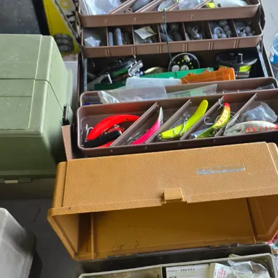 Sale Photo Thumbnail #79: Collection of vintage plastic tackle boxes filled with various fishing tackle, lures, lead weights, and fishing lines.