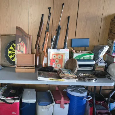 Sale Photo Thumbnail #61: Collection of outdoor and sporting goods, including air rifles, target games, dartboard set, vintage board games, and various insulated coolers.