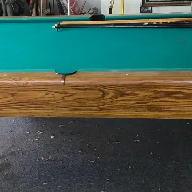 Sale Photo Thumbnail #111: Full-size pool table with green felt top and faux-wood laminate base, complete with cues and a racked set of billiard balls.