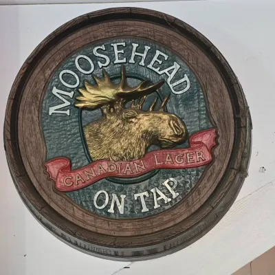 Sale Photo Thumbnail #104: Vintage Moosehead Canadian Lager 3D barrel-head style bar sign featuring a raised gold-tone moose head.