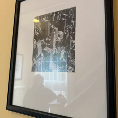 Framed black-and-white aerial photograph of the Chrysler Building and New York City cityscape, mounted in a wide white mat and black frame.