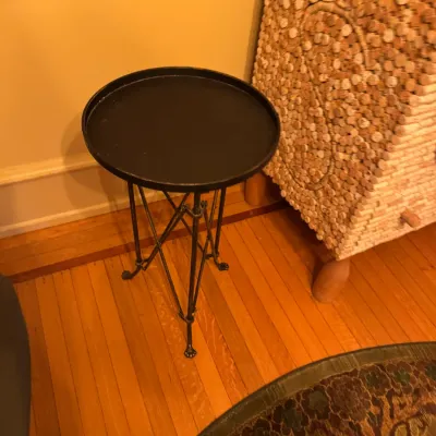 Black wrought iron tray top side table featuring crisscross legs with claw feet.
