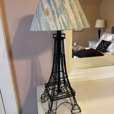 Black metal Eiffel Tower table lamp with a blue and white patterned lampshade.