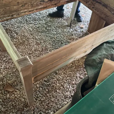 Large rustic wooden raised garden bed planter box showing heavy weathering and soil staining on the interior.