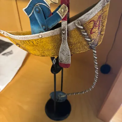 Vintage-style painted metal kinetic balance toy featuring a sailor in a boat named "Salty Dog".
