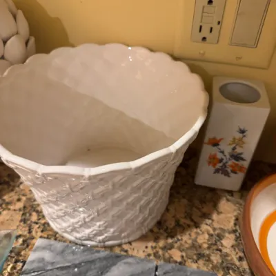 White glazed ceramic basket-weave planter, paired with a small rectangular ceramic floral vase on a granite countertop.