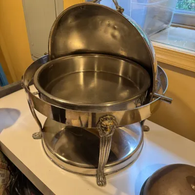 Vintage silver-plated roll-top chafing dish featuring ornate lion's head legs and paw feet.
