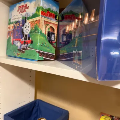 Vintage Thomas the Tank Engine & Friends melamine dish set in original box, sitting on a shelf alongside a boxed menorah.