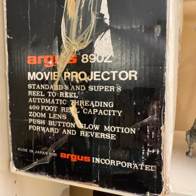 Vintage Argus model 890Z Standard 8 and Super 8 movie projector in its original box with visible tape wear.