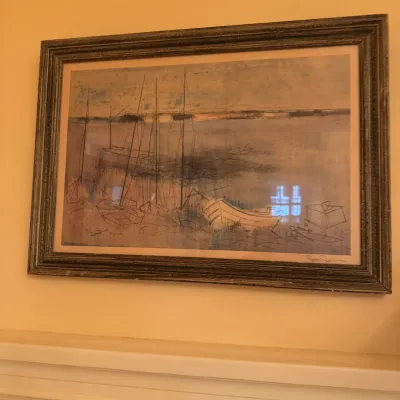 Mid-century modern framed harbor print depicting sailboats, signed in the lower right corner and set in a rustic metallic frame.