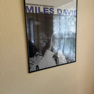 Framed Miles Davis poster featuring a photograph by Francis Wolff, encased in a simple black thin frame.