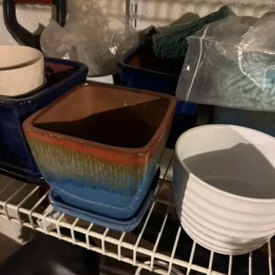 Collection of glazed ceramic plantery pots, including a square multi-colored drip glaze pot with a matching saucer and a ribbed white...