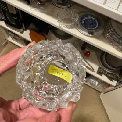 Heavy cut crystal votive or candle holder with faceted design, marked with a handwritten 'Tiffany' label inside the base.