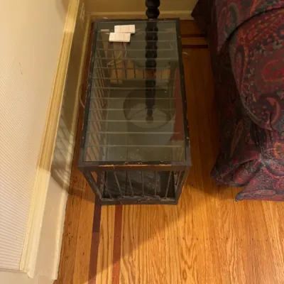 Vintage dark-stained wooden crate-style end table featuring vertical side slatted bars, a glass top insert, and some surface finish wear...