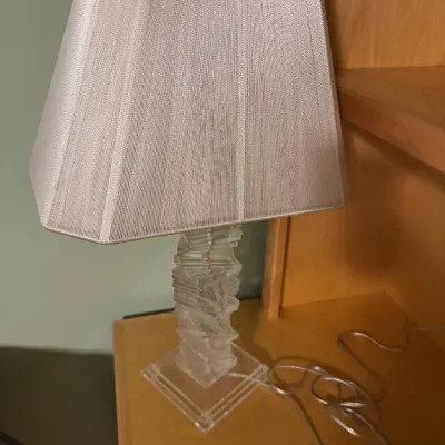 Contemporary table lamp featuring a stacked lucite block column base and a cream trapezoidal fabric shade.