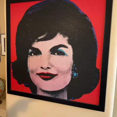 Framed pop art portrait print of Jacqueline Kennedy in the style of Andy Warhol featuring a bold red background.