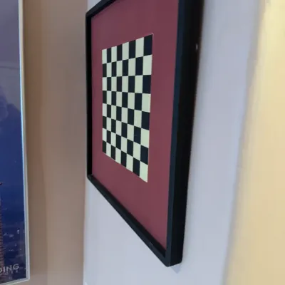 Framed geometric checkerboard art print featuring a black and light green pattern with burgundy matting and a simple black frame.