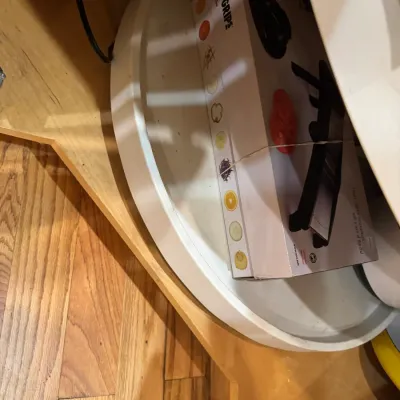 Boxed OXO Good Grips chef's mandoline slicer resting inside a white kitchen cabinet turntable organizer.