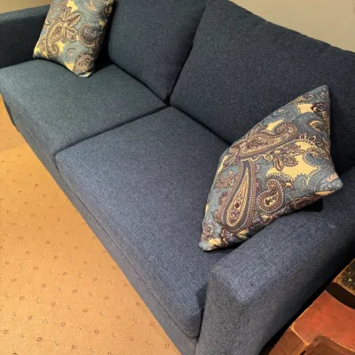 Contemporary blue woven fabric sofa with clean track arms, accompanied by two matching paisley throw pillows.