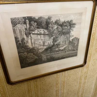 Framed black and white architectural landscape etching, featuring a cliffside scene, presented in a vintage gilt frame with a white mat.