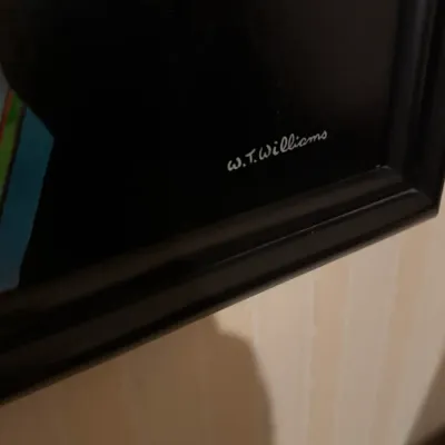 Close-up of an artist's signature reading "W. T. Williams" in the corner of a framed painting.