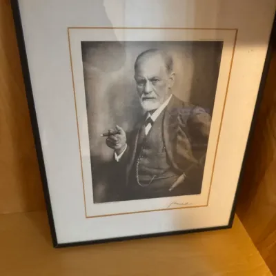 Framed black and white portrait print of Sigmund Freud holding a cigar, mounted with a double mat in a simple thin black frame.