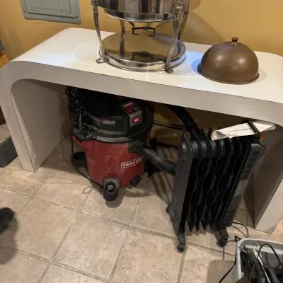 Silver-plated dome-top chafing dish paired with household items, including a Craftsman shop vacuum and portable radiator heater displayed...