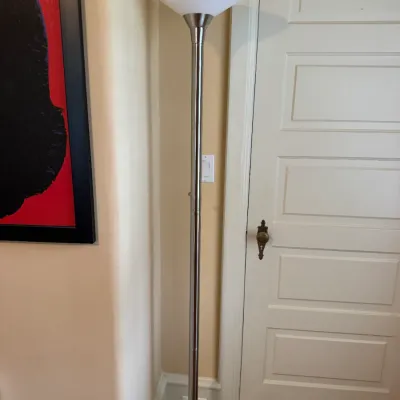 Modern torchiere floor lamp featuring a brushed nickel metal stem and a white frosted glass shade.