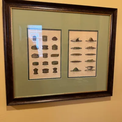 Framed dual culinary prints depicting vintage French pastry and dish illustrations, set in a green mat and dark wood frame.
