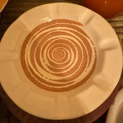 Vintage ceramic ashtray featuring a off-white rim and a brown spiral-patterned center dish.