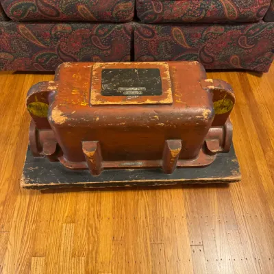 Vintage industrial wooden foundry pattern mold in reddish-brown paint mounted on a wooden base.